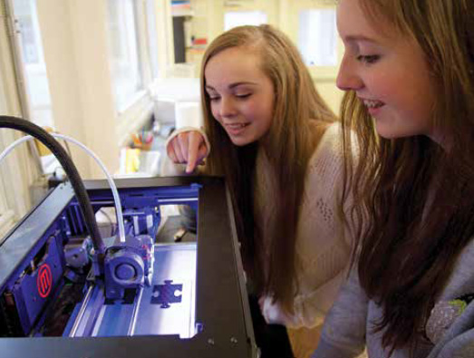 Walker School freshmen Chandler Hanke (left) and Ella Richardson printing "Best Friends" puzzle pieces.